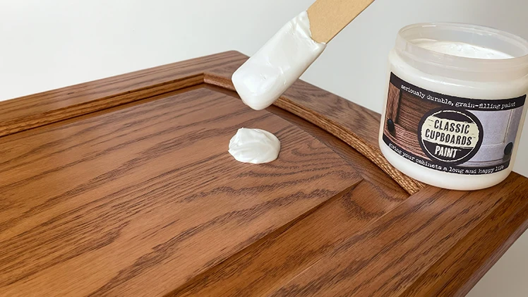 Pouring out Classic Cupboards Paint™ onto a cabinet door