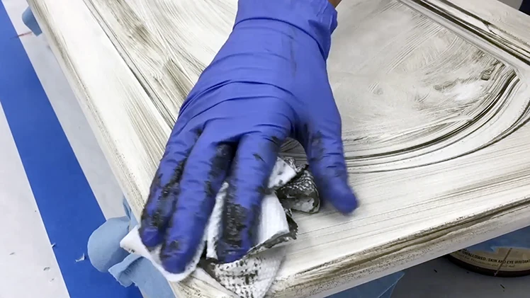 Hand waxing a cabinet door in the Classic Cupboards™ Studio